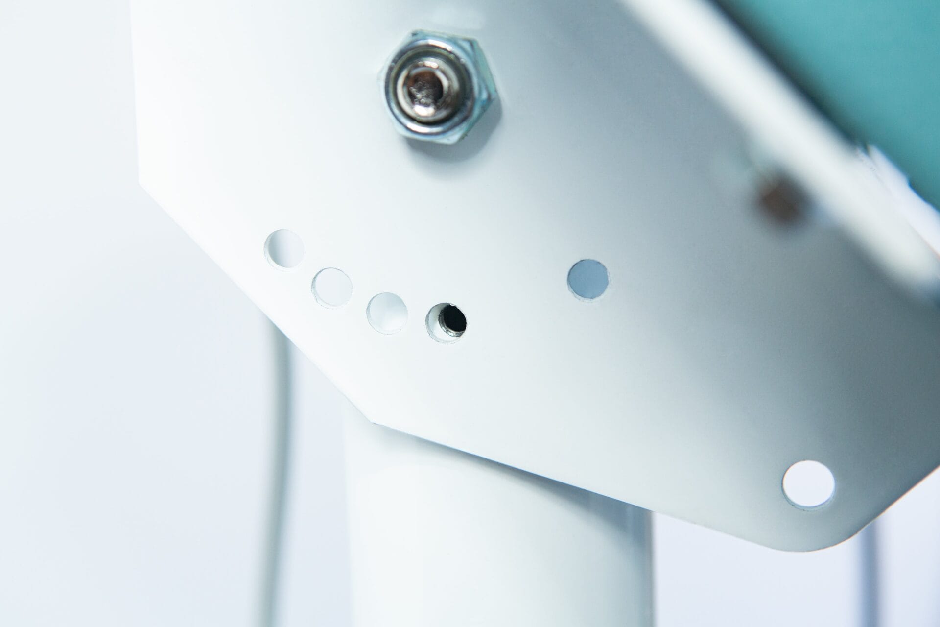 Close-up of the Vertical Foot Heat Sealer VHVD 450mm Double 10mm by Venus, showing a white metal bracket with several small circular holes and a bolt.