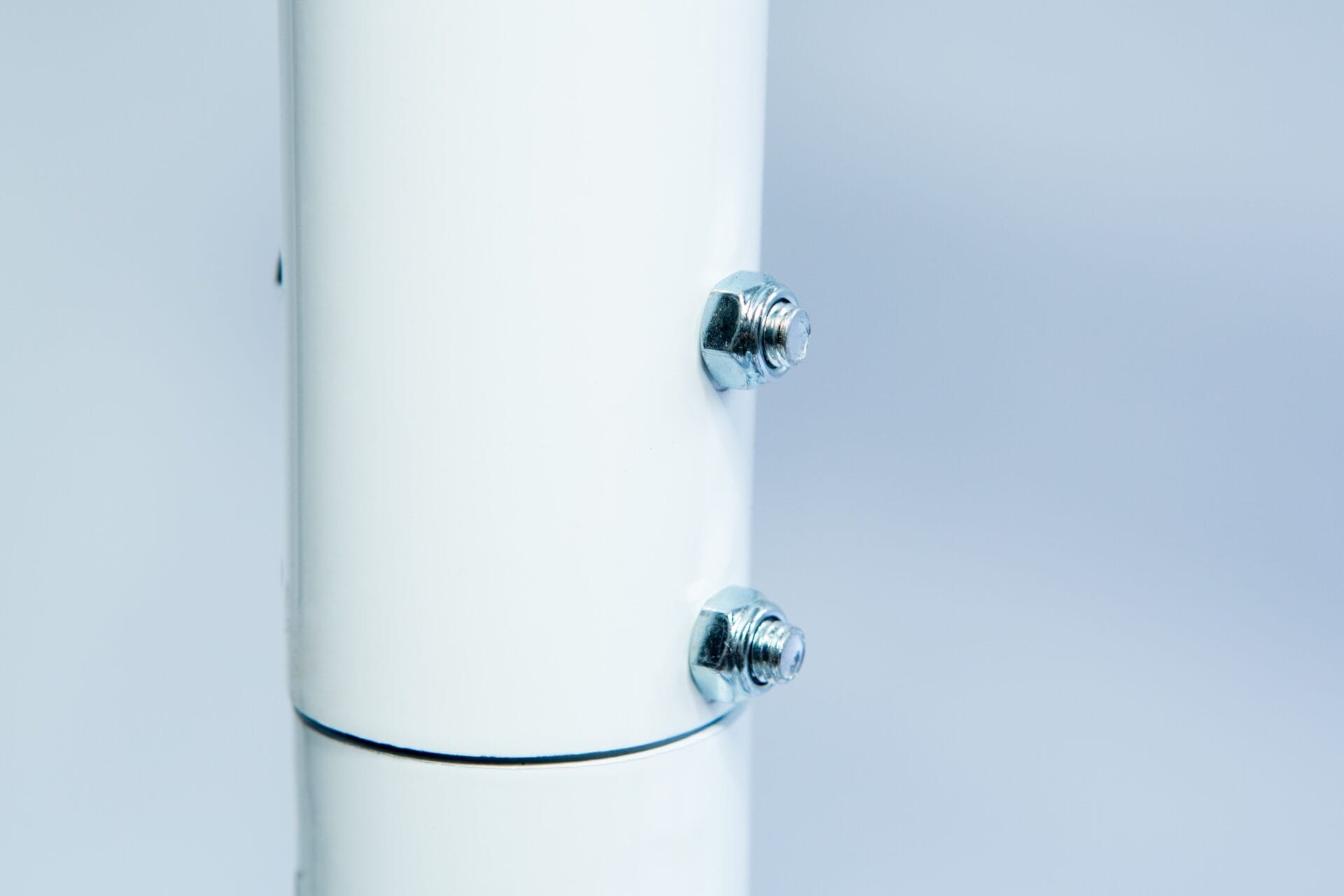 Close-up of two metal bolts securing the Vertical Foot Heat Sealer VHVD 450mm Double 10mm | Venus, featuring a white cylindrical tube against a light background.
