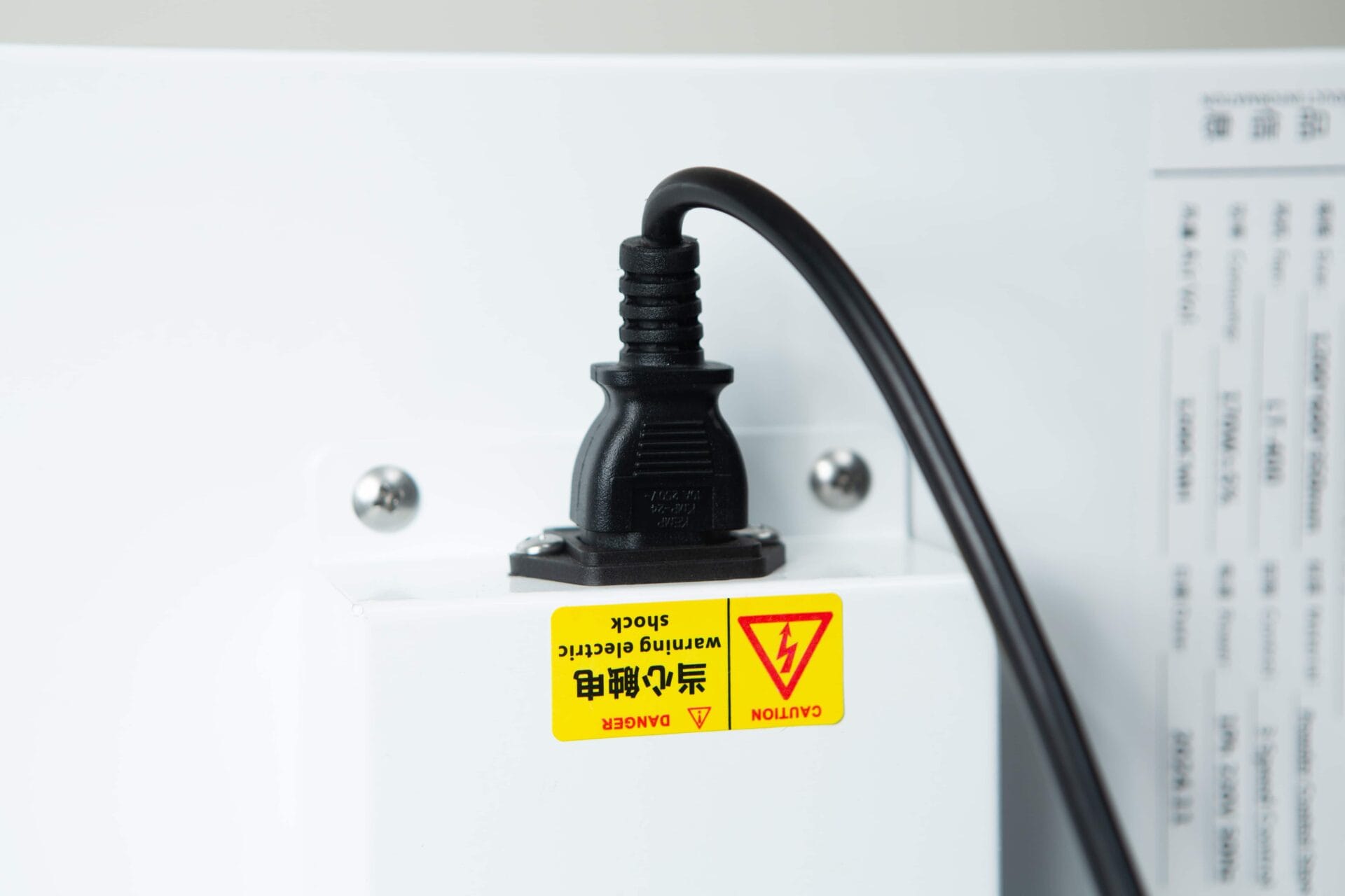 A Laminar Flow Hood H14 with prefilter (120x60x35cm) is plugged in with a black power lead to a white socket featuring an English and Chinese yellow electric shock warning label.