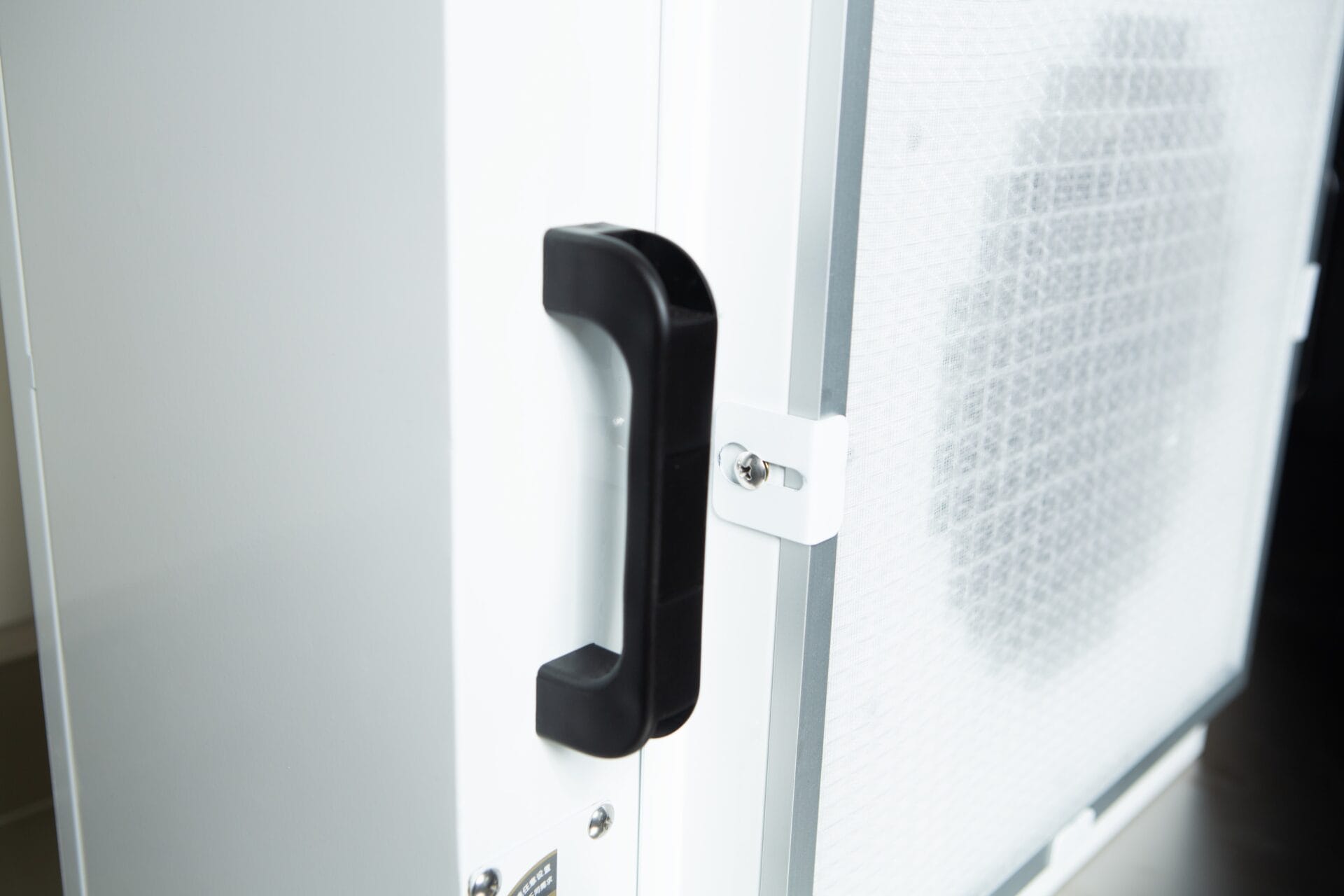 Close-up of a black handle on the Laminar Flow Hood H14 w/prefilter (120x60x35cm), a white rectangular device with a mesh filter panel.