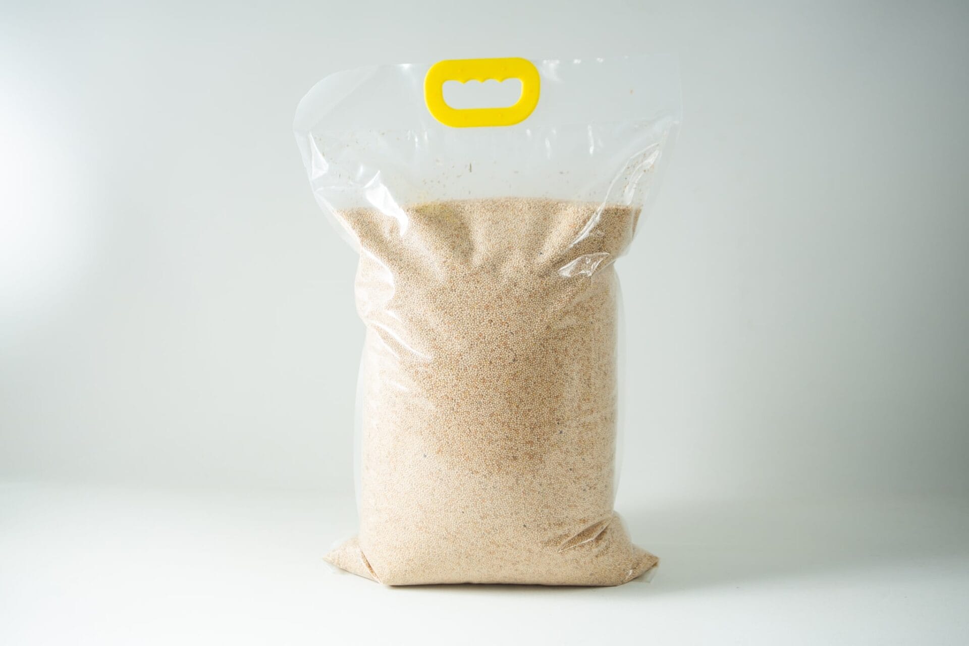A clear plastic bag containing Certified Organic Biodynamic Rye berry grain, light brown granules, sealed with a yellow handle at the top.