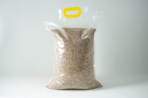 A sealed plastic bag of Certified Organic Biodynamic Rye berry grain, filled with brown grains and featuring a yellow handle at the top.