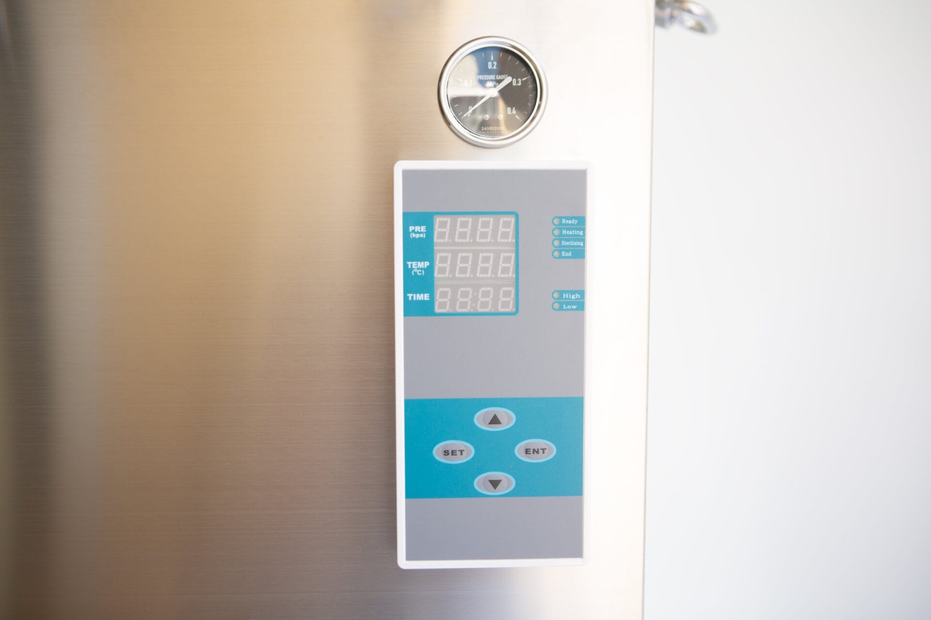 Close-up of a digital control panel and gauge on a stainless steel appliance.