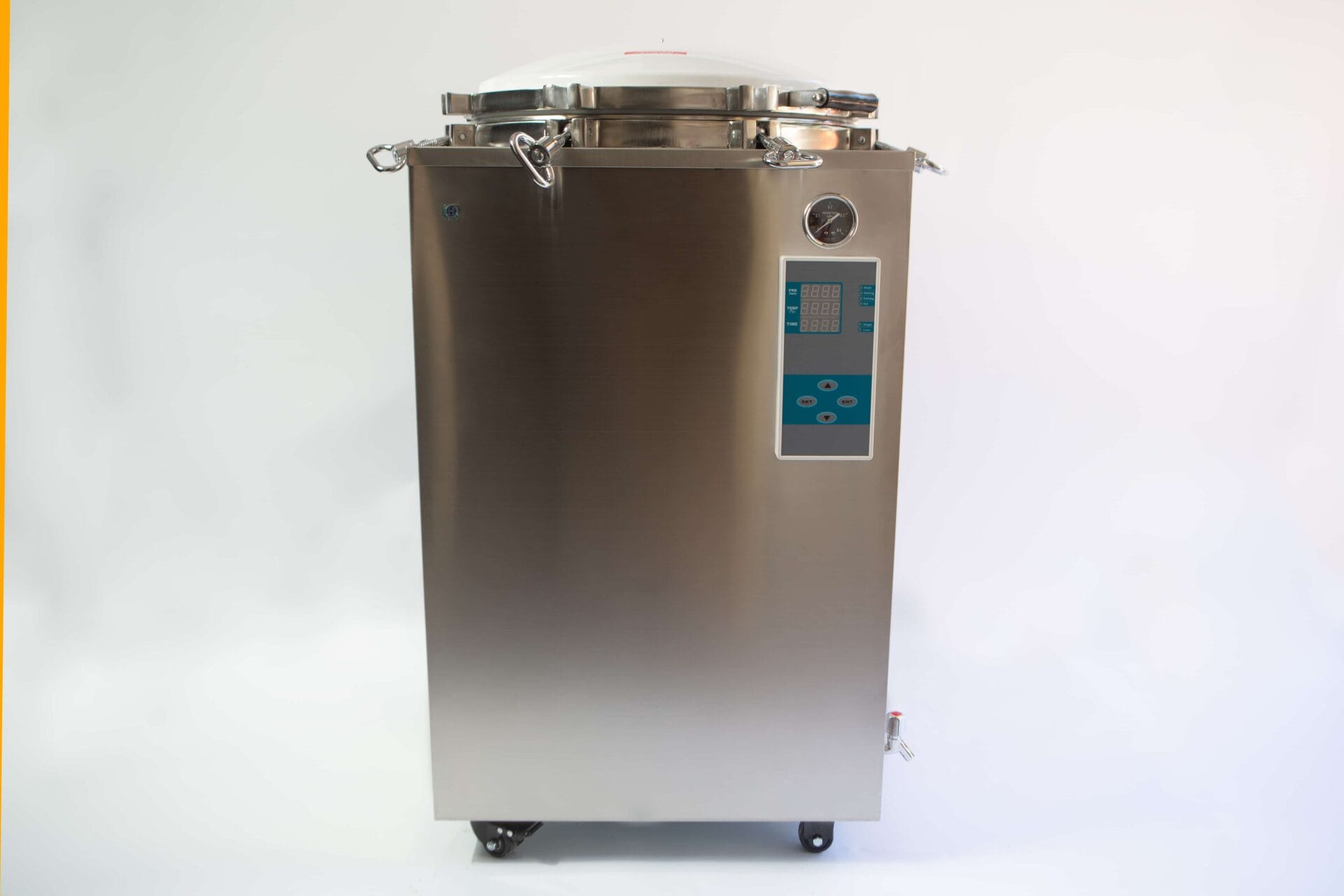 A stainless steel autoclave machine with a control panel and pressure gauge on the front.