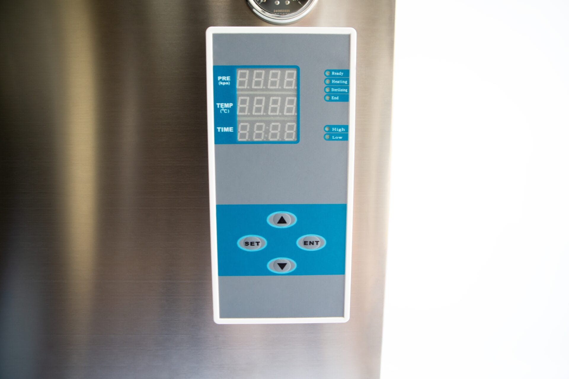 Close-up of a digital control panel with display screens and arrow buttons on a stainless steel surface.