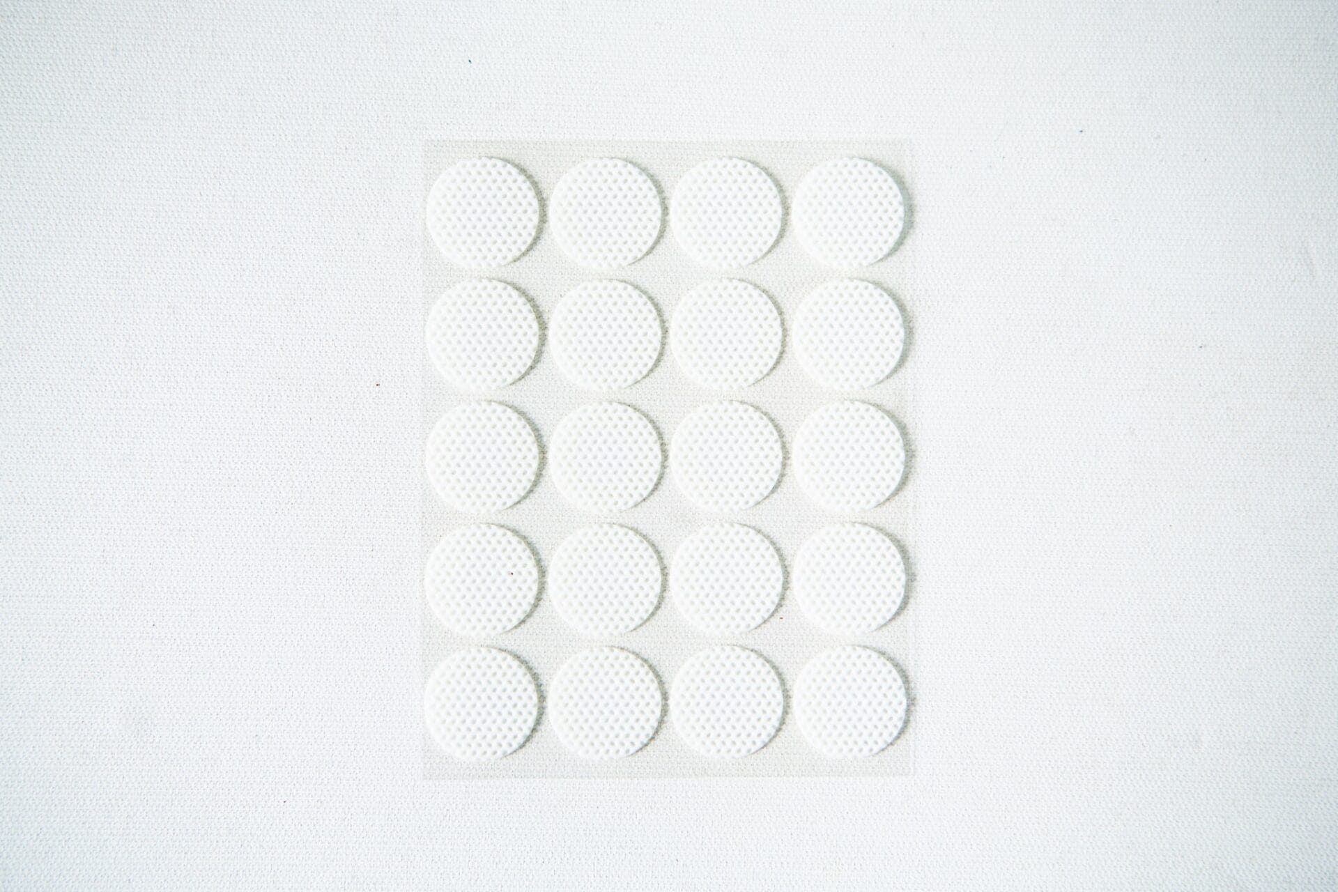 A sheet of 18 round, white adhesive labels arranged in a grid on a white background.