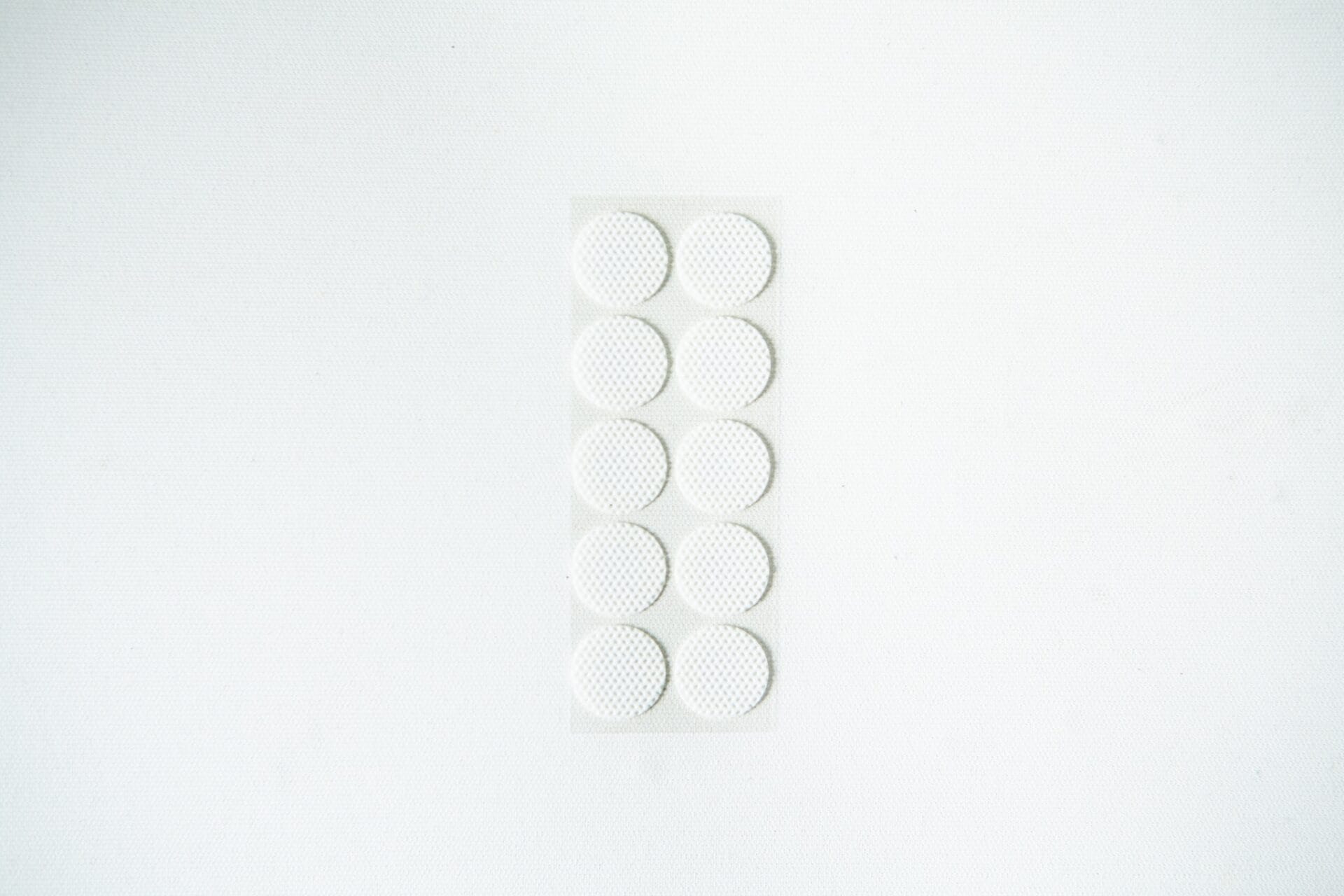 A blister pack containing ten round, white tablets on a plain white background.