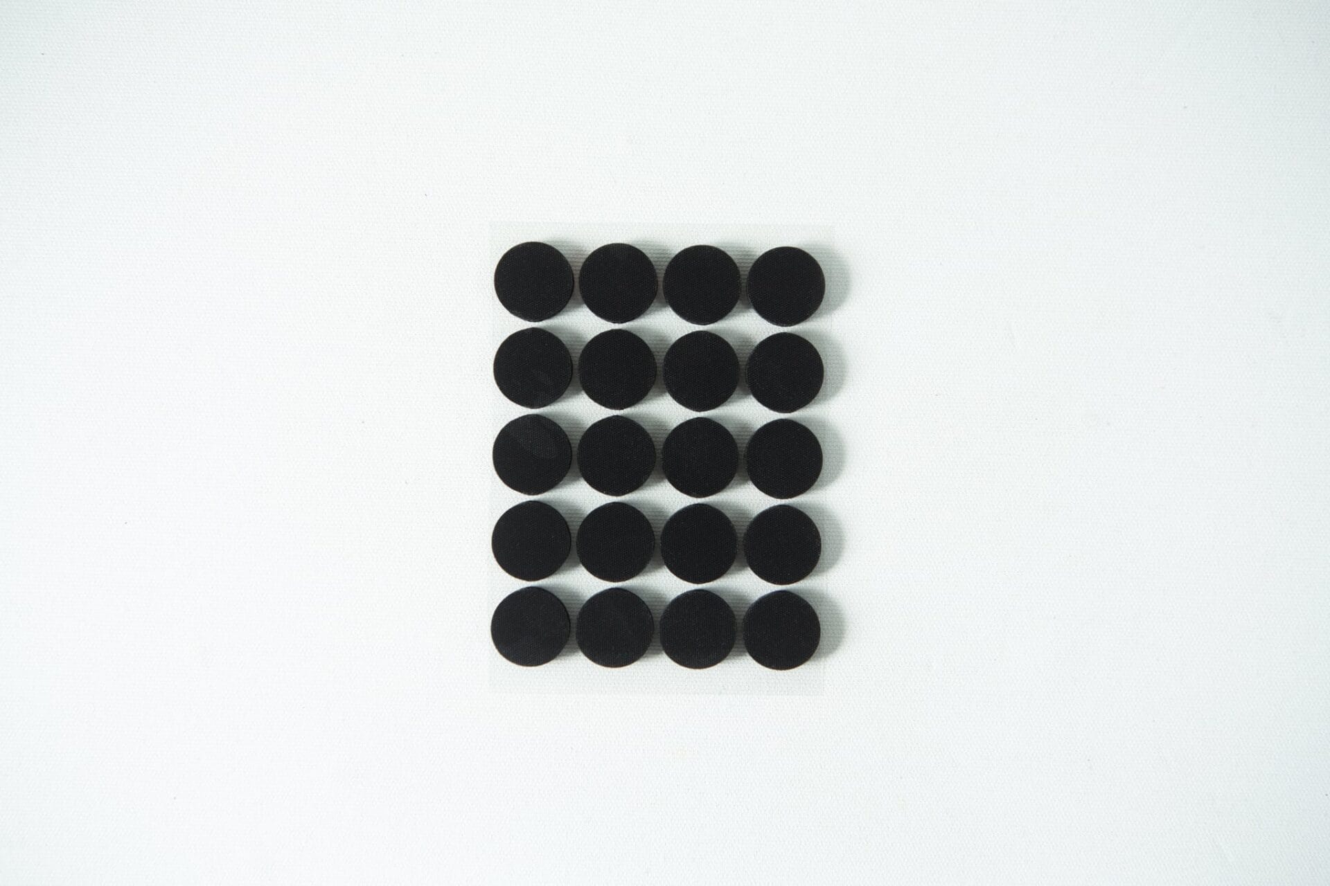 Twenty black circular dots arranged in a 4 by 5 grid on a white background.