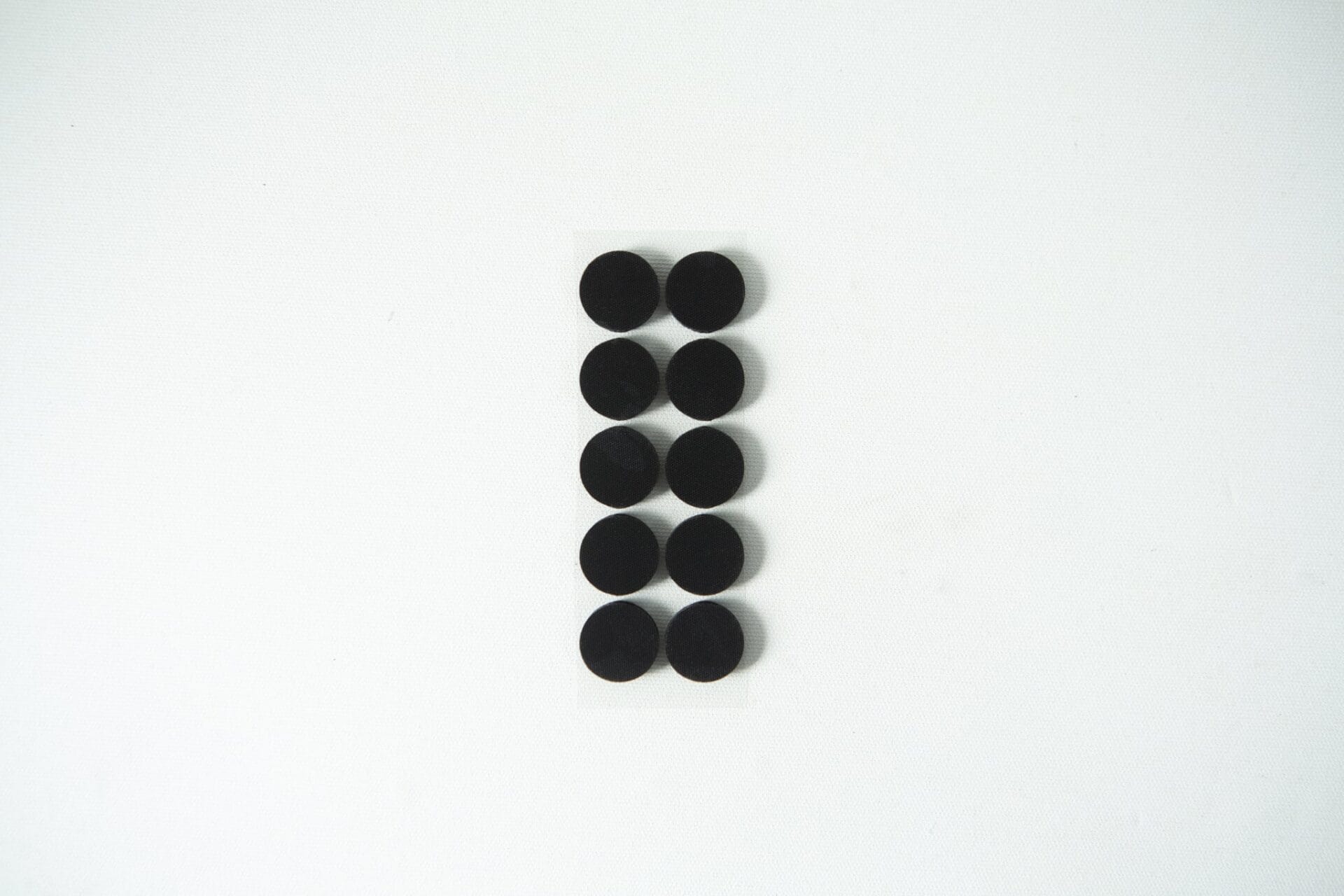 Ten small black circular pads arranged in two columns on a white background.