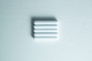 Five white Magnetic Stirrer Bars (8×50mm PTFE Lab Spinner Cylinders) are aligned horizontally on a light textured background.