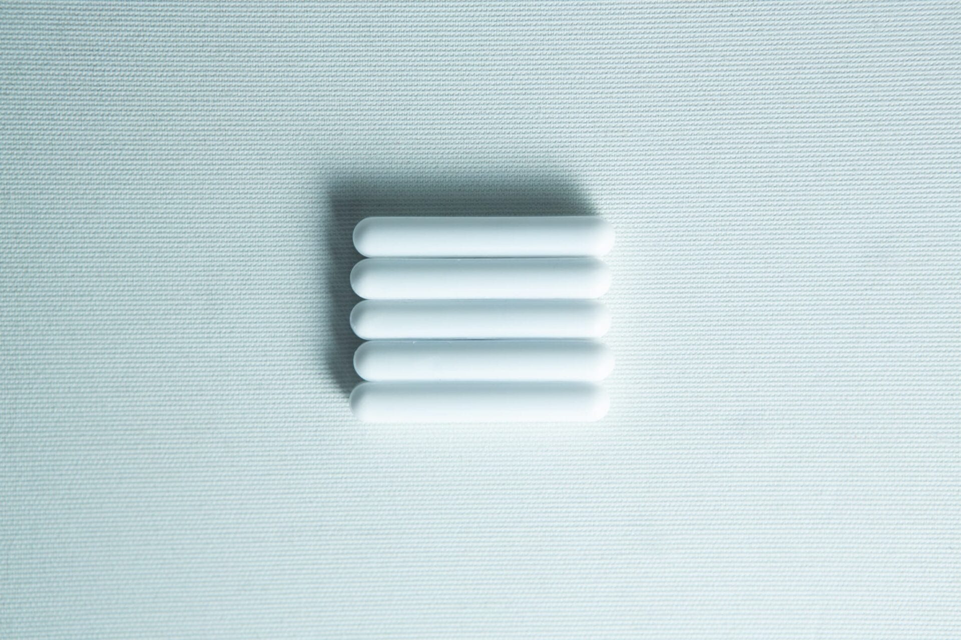 Five white Magnetic Stirrer Bars (8×50mm PTFE Lab Spinner Cylinders) are aligned horizontally on a light textured background.