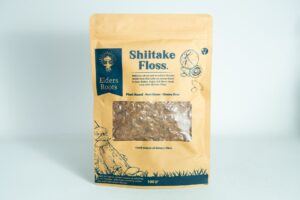 A brown bag labelled "Shiitake Mushroom Floss | Vegan" with a clear window displays the shredded contents inside.
