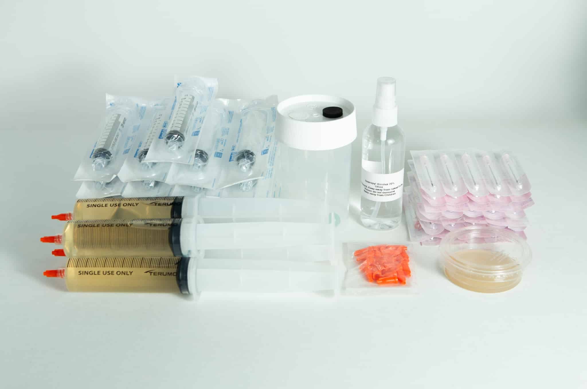 Liquid culture to Liquid Culture Expansion Kit with syringes, spray bottle, petri dish, and plastic containers displayed on a white background.