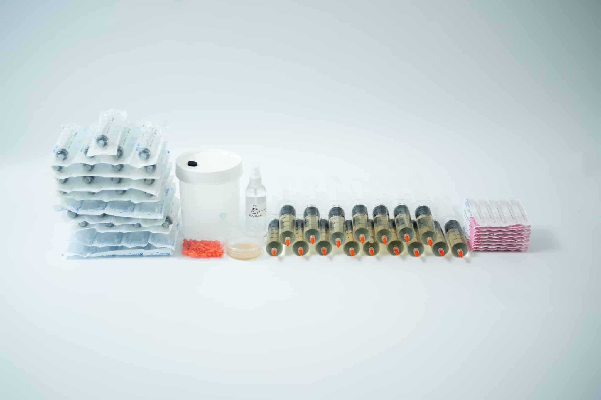 The Liquid culture to Liquid culture expansion Kit is displayed on a white background with syringes, blister packs, a bottle, and a container.