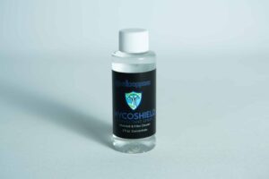 A small bottle labelled Long Needle Disinfectant Spray with a white cap on a light background.
