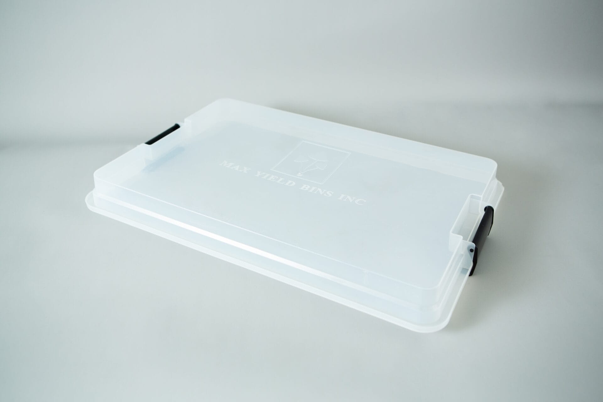 Clear plastic colonisation lid with black handles, ideal for a monotub kit or growing mushrooms, lying on a white surface.