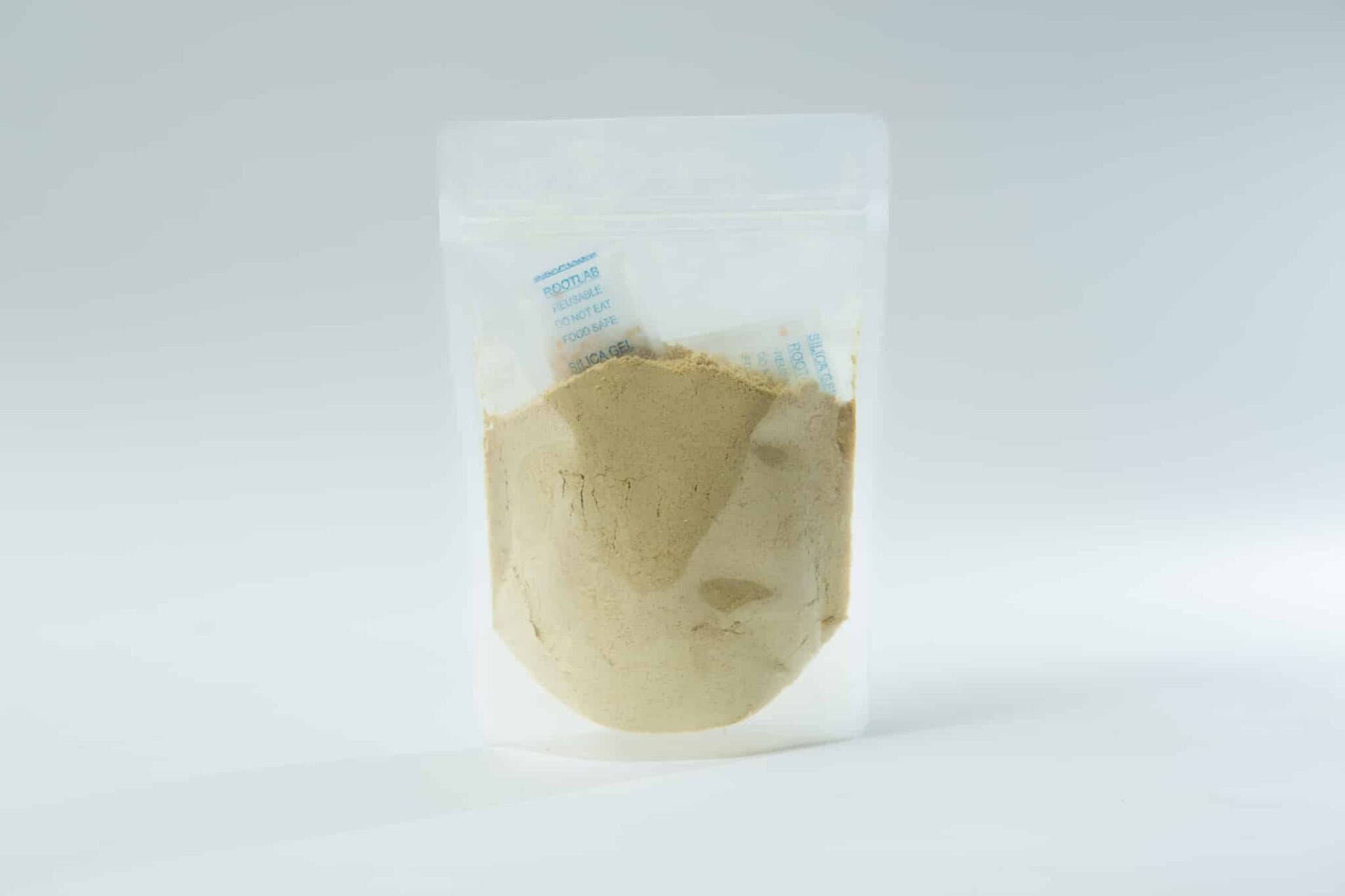A clear plastic pouch containing light brown Freeze-Dried/ Dehydrated Mushroom Lion's Mane powder with a small silica gel sachet inside.