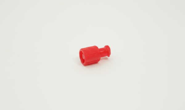 Small red sterile syringe cap with a ridged grip, placed on a plain white background.