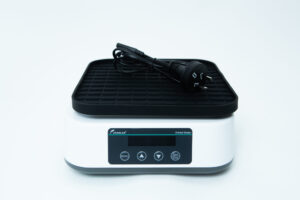 A digital laboratory orbital shaker with a power lead placed on top, on a white background.