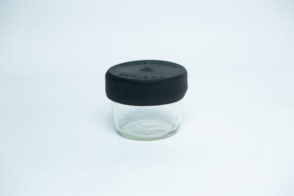 A small, empty wide-mouthed glass jar with a Silicone Mason Jar Rubber Lid is placed on a plain white background.