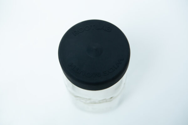 A glass jar with a wide mouth and a black silicone rubber lid labelled "Silicone Mason Jar Rubber Lid | Wide Mouth" on a white background.