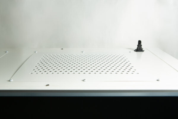 A small Darth Vader figurine stands on a white surface with ventilation holes.